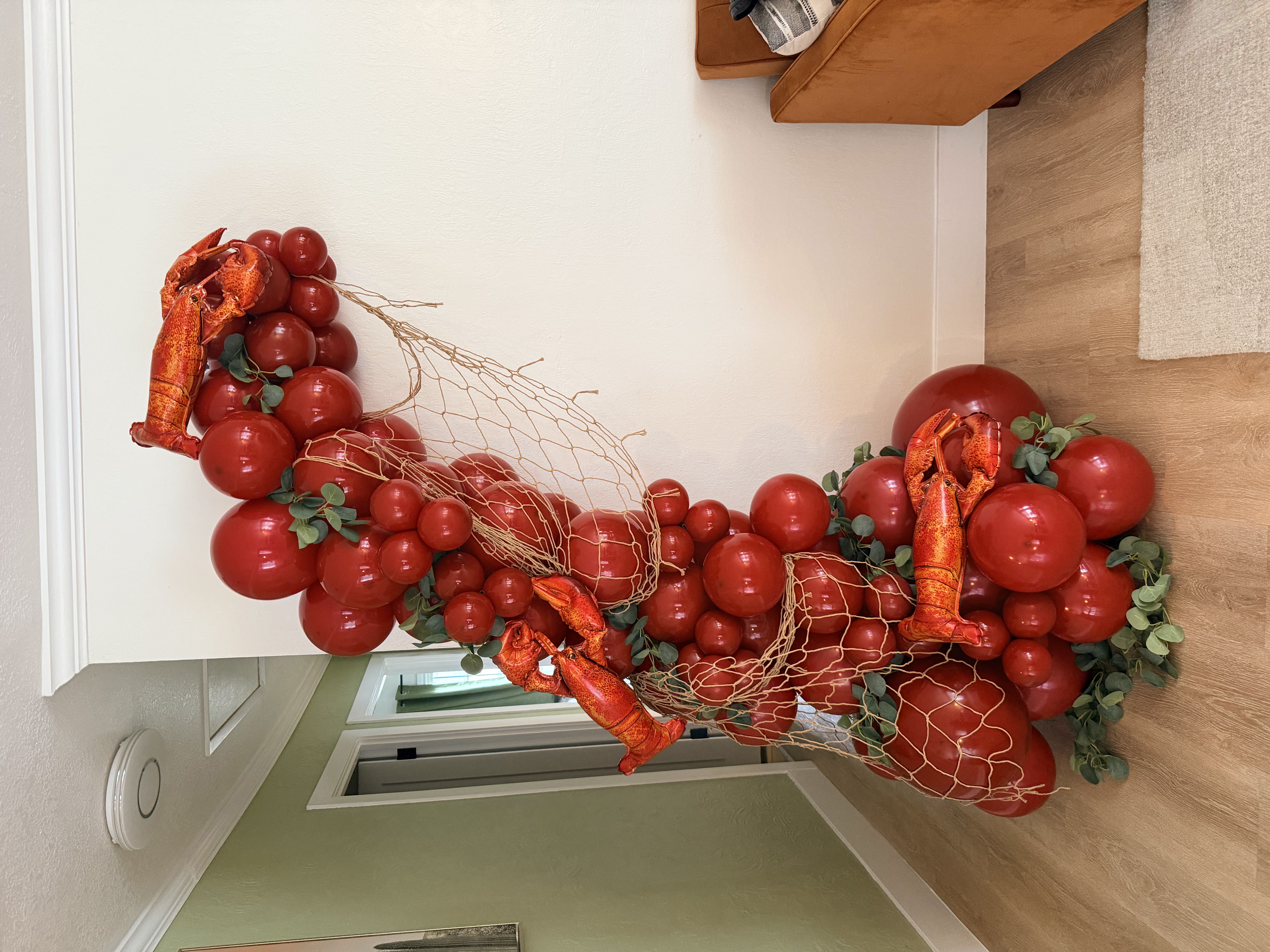 Lobster themed balloon column with netting and greenery